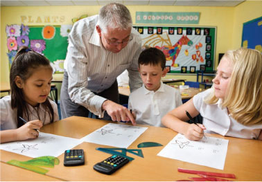 teacher helping students in a classroom