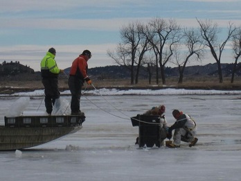 Workers cleaning up pipeline oil spill in frozen water in Yellowstone.