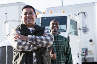 A photograph of two men standing in front of a truck.