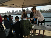 Students perform water quality experiments with EPA staff at the Canoemobile Event at the Charlestown Navy Yard. Students used USGS test kits to measure temperature, pH and turbidity.