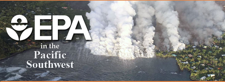 Aerial photograph of steam or white smoke rising from Kilauea lava flows as lava enters Kapoho Bay.