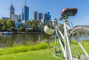 bike on a river bank with cityscape in background