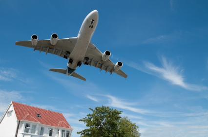 Airplane flying over a house.