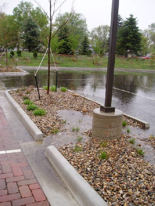 A parking lot in Fort Collins, Colorado show pavers and a flow through in a parking lot show slow flow of stormwater.