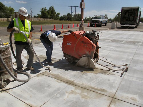 Construction workers install slotted concrete to form a pervious pavement for stormwater runoff.