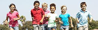 Picture of small children running outside on a bright sunning day.