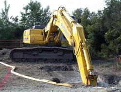 Crane digging hole for sampling pollutants in a specified area