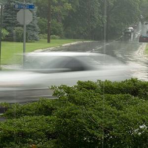 Car driving through flooded street in rain