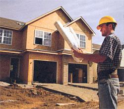Picture of construction worker next to new house being built