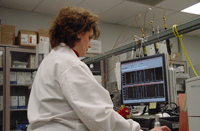 Photo of chemist examining data on gas chromatograph.