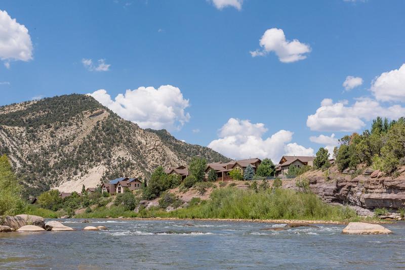 scenic view of mountain stream with houses on the opposite shore
