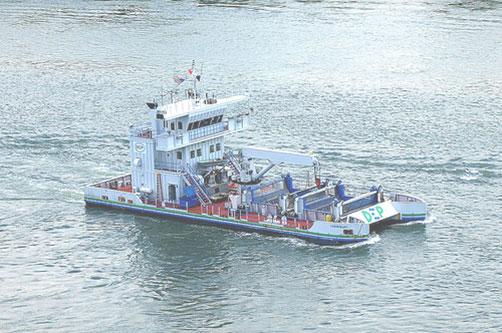 Trash skimming vessel: appears like a blend of a catamaran/double-hulled ship and a barge tug boat. 