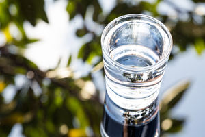 Refreshing water in transparent glass with reflection