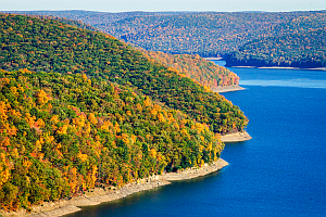 Lake in the mountains with trees showing colored leaves of autumn.
