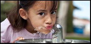 Closeup of girl drinking from water fountain.