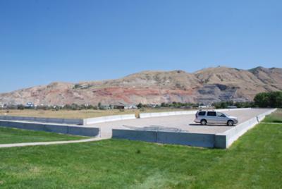 Parking area over capped ground next to a revegetated dog park area at the Rose Park Sludge Pit site