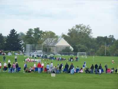 Spectators watch a soccer game at the new fields on the Whitmoyer Laboratories site