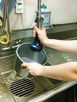 Commercial sink, man spraying a pot