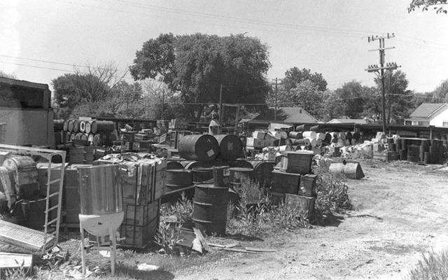 Image of drums, debri and other wastes collecting at CCI site.