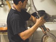 Image of person using a pre-rinse spray valve.