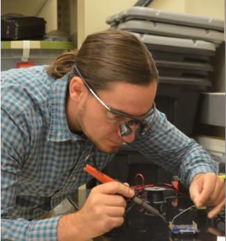 A lab technician tests and fixes a sensor