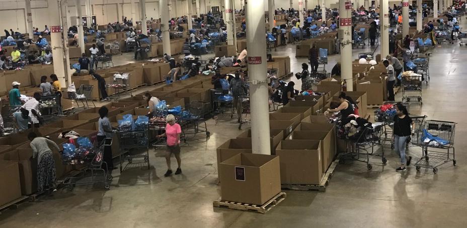 This is a picture of a warehouse where merchandise has been laid out for L Brand associates to go through and purchase at a discount.