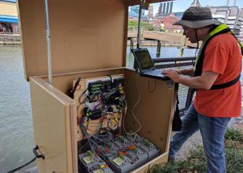 A USGS staff member reads data collected by the Village Blue Baltimore water quality sensors