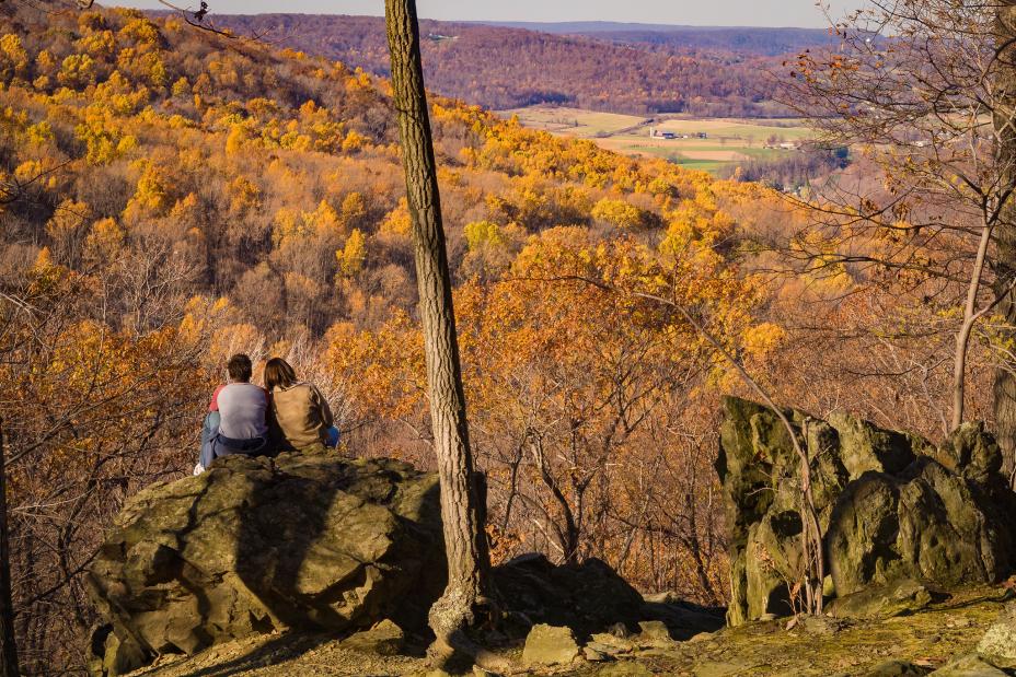 People enjoying the view of fall leaves from a Cunningham Falls State Park in Maryland. Photo by Eric Vance