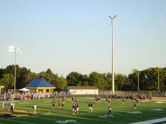 Wind turbine next to high school football field