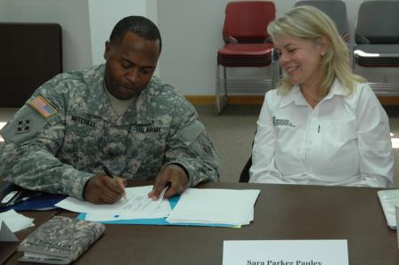 Col. Mitchel and Sara Parker Pauley sign a document about their joint effort to conduct studies leading to restoration projects along the Meramec and Big Rivers.