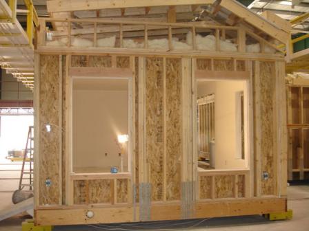 Closeup of modular home under construction on factory floor.