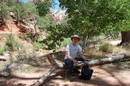 Researcher Mike Tryby sits on a tree while out in the field