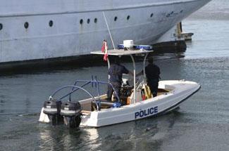 A photograph of a police boat next to a ship.