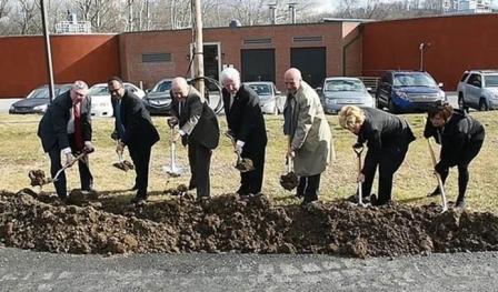 Officials scoop shovels of dirt as part of the groundbreaking ceremony for the Reading wastewater plant.