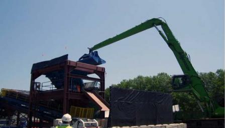 Workers at the processing facility used excavators with environmental clamshell buckets to load the contaminated sediment and debris onto a trommel which began the process of separating the material.