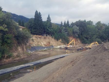 River channel with construction crews and pipes