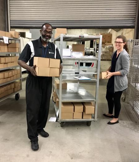 This is a picture of two kitchen workers prepping food for donation.