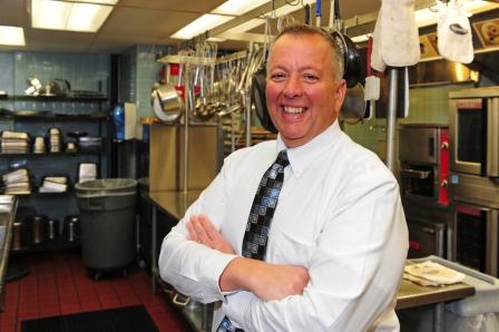 This is a picture of a man standing in a kitchen