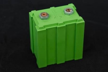 This is a picture of a green battery in the shape of a box. The background of this picture is black.