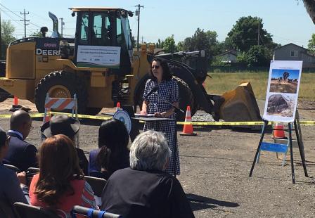 Acting Regional Administrator Alexis Strauss giving a speech in front of construction equipment