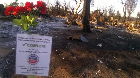 Sign posted on burned property: This property's Household Hazardous Waste removal has been designated COMPLETE by U.S. EPA.