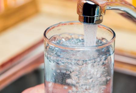 Someone fills a glass with tap water