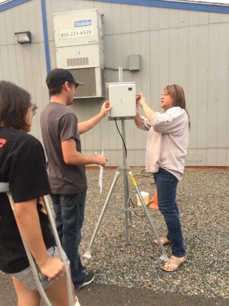 Heritage University students setting up a community air monitor