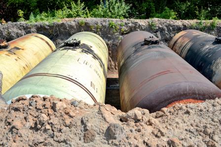 Photograph of underground storage tanks; soil has been removed from the top of the tanks to reveal where they are located underground. 