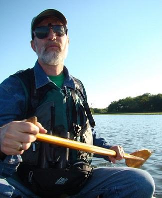 Walter Berry in a canoe on his way to count sparrows on the salt marsh.