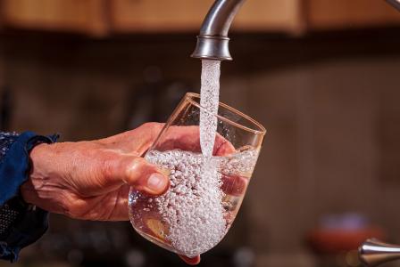 Water glass being filled from a faucet