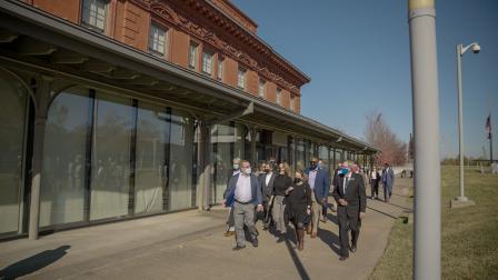 Wheeler and others walking past a glassed-in wall