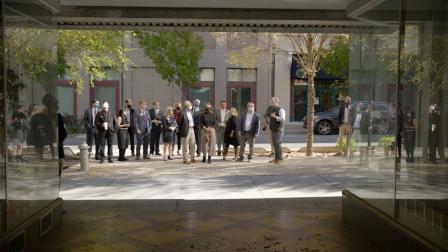 Wheeler and a large group in a courtyard, all wearing masks