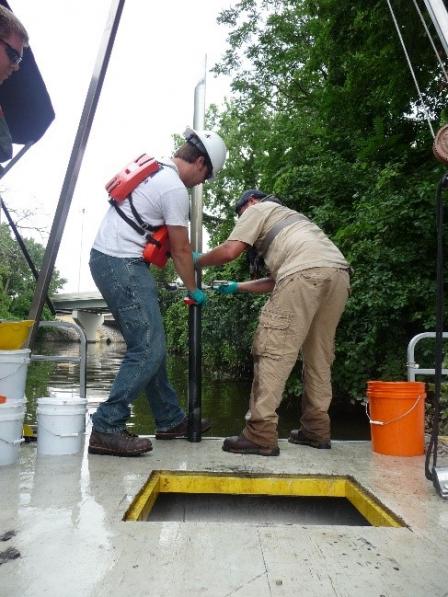 photo of U.S. EPA and a contractor collecting a sediment core on Swan Creek to determine level of contamination within the creek. Photo credit: Ohio EPA