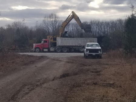 Truck being filled with contaminated soil before heading to landfill.